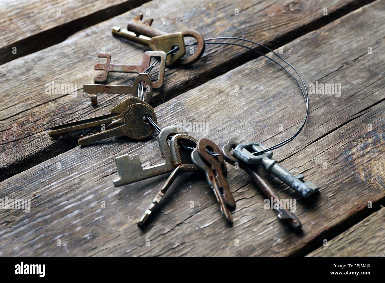 Mazzo di chiavi vecchie su sfondo di legno Foto Stock