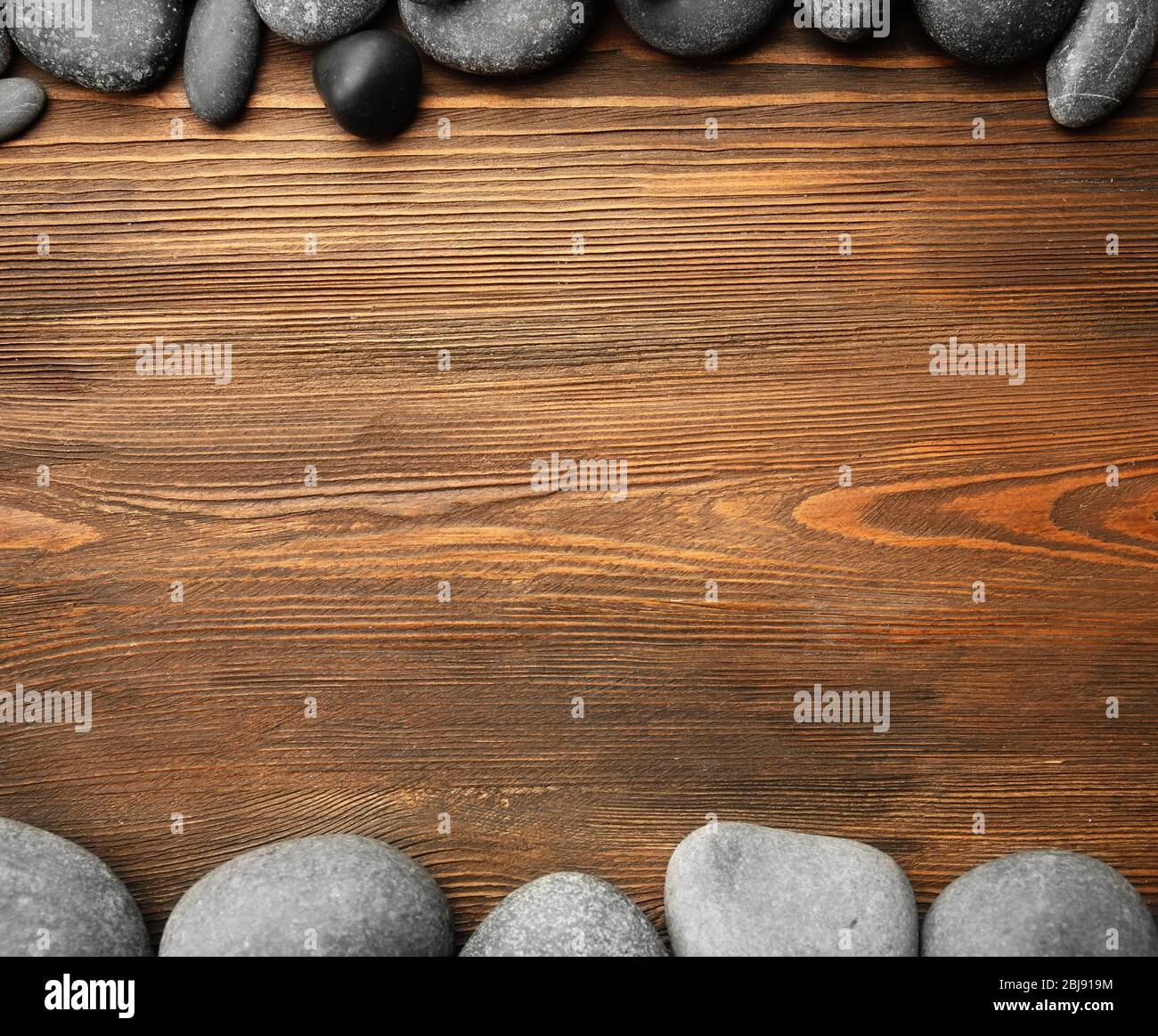 Pietre Spa e bastoni di bambù su sfondo di legno Foto Stock