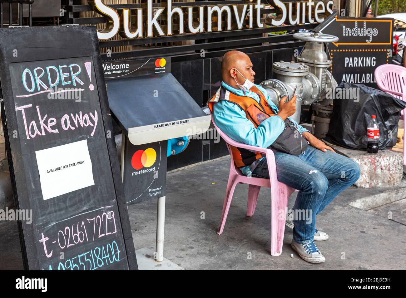 Tassista in moto in attesa di ordine di prelievo al ristorante durante la pandemia Covid 19 a Bangkok, Thailandia Foto Stock
