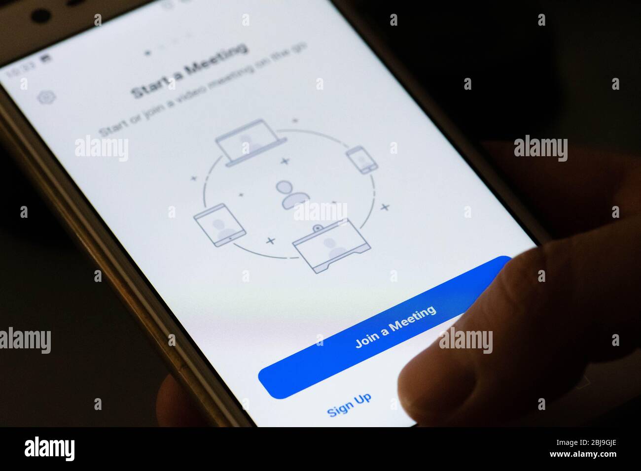 App Zoom Video Communications sullo smartphone, videotelefonia, videoconferenze e chat online per riunioni, lavorare da casa con le dita Foto Stock