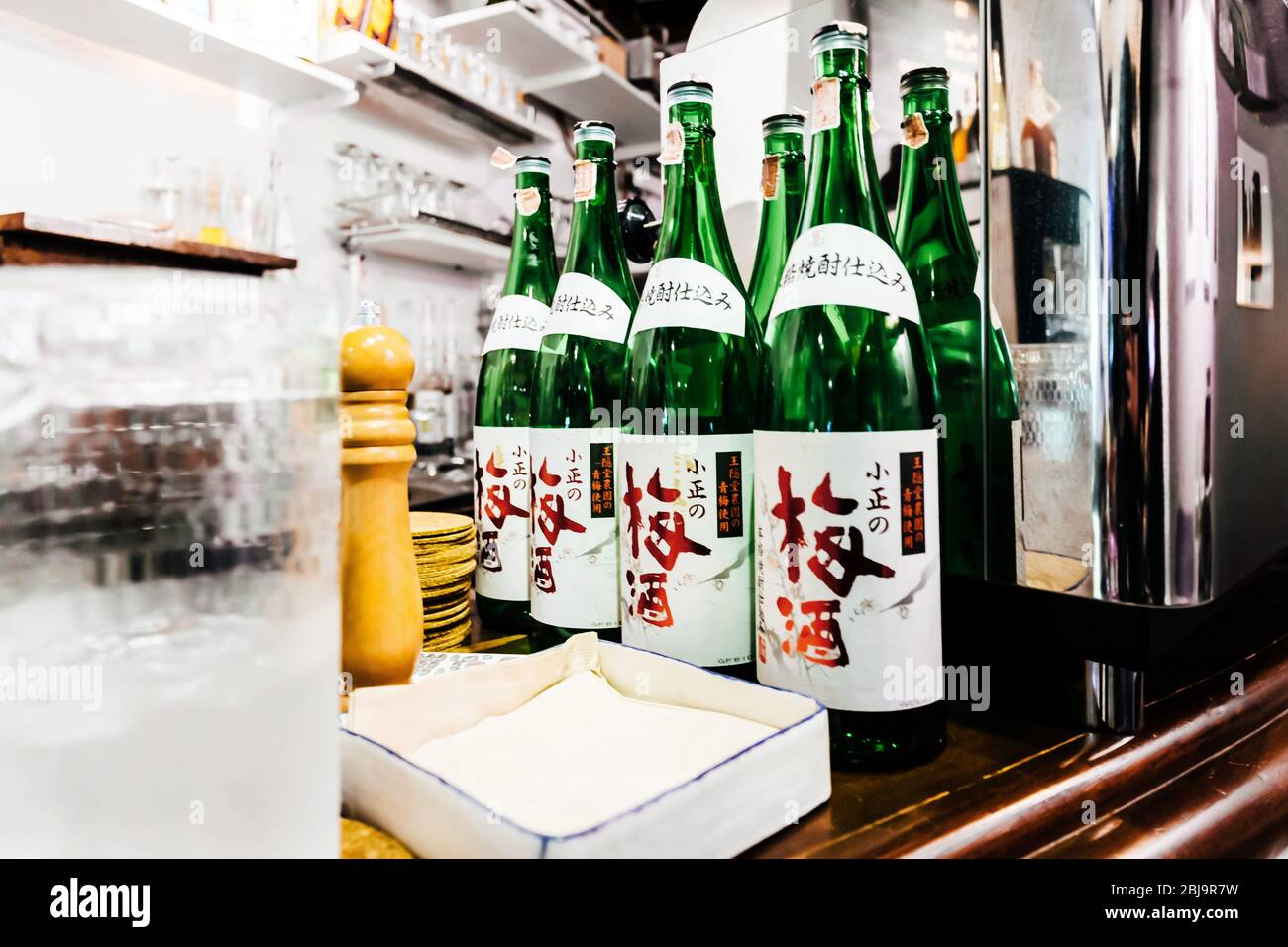 Molte bottiglie di sake giapponese al banco del ristorante giapponese Izakaya. Foto Stock