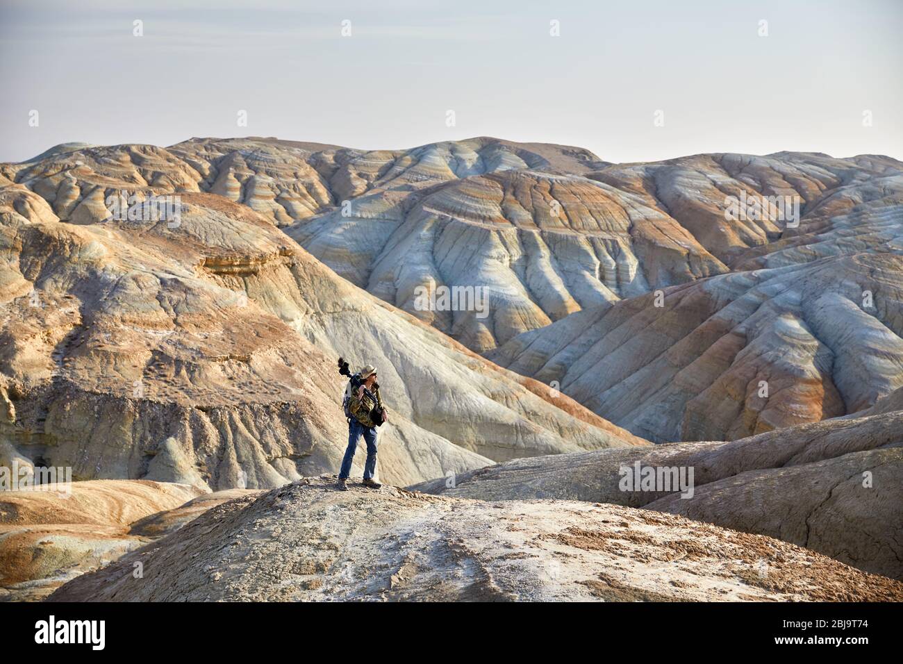 Turistico con fotocamera e zainetto nel surreale delle montagne del deserto Foto Stock