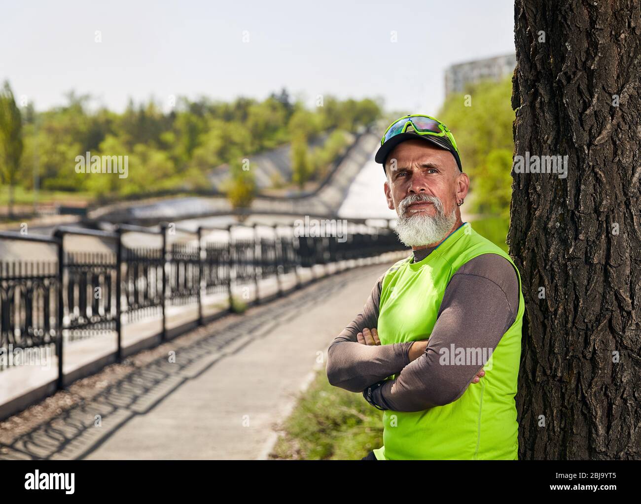 Ritratto di uomo anziano con barba grigia presso il parco della città di mattina. Uno stile di vita sano concetto Foto Stock