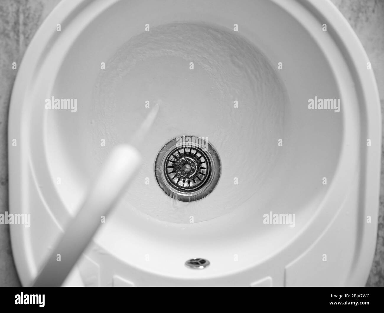 Acqua che scorre dal rubinetto nel lavandino in cucina Foto Stock