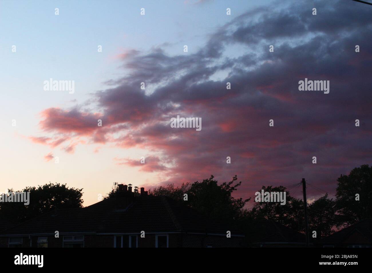 Tramonto rosa scuro nuvoloso a Manchester, Inghilterra Foto Stock