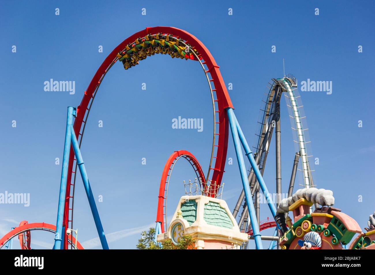 Dragon Khan, Port Aventura World, Salou, Spagna. Bellissimo scatto del treno con i piloti capovolti in un enorme loop. Giornata estiva soleggiata. Agosto 2019. Foto Stock