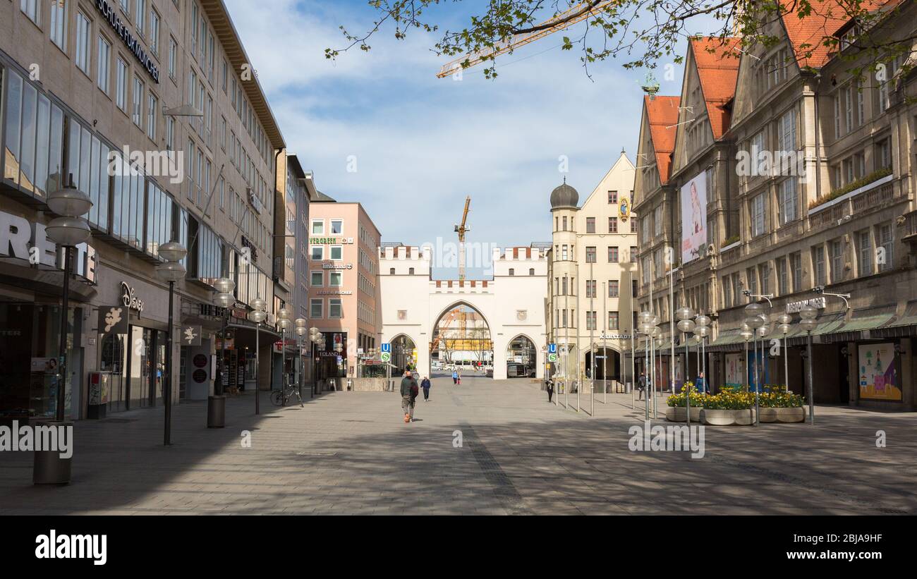 Panorama con zona pedonale (Neuhauser Straße), edifici storici e il Karlstor (porta della città). Solo poche persone a causa di Coronavirus (Covid-19). Foto Stock