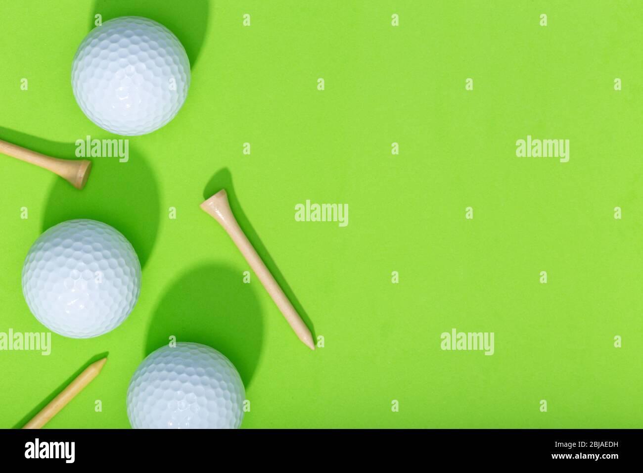 Sfondo golf. Gruppo di palline da golf e tee su sfondo verde. Spazio di copia della vista superiore Foto Stock