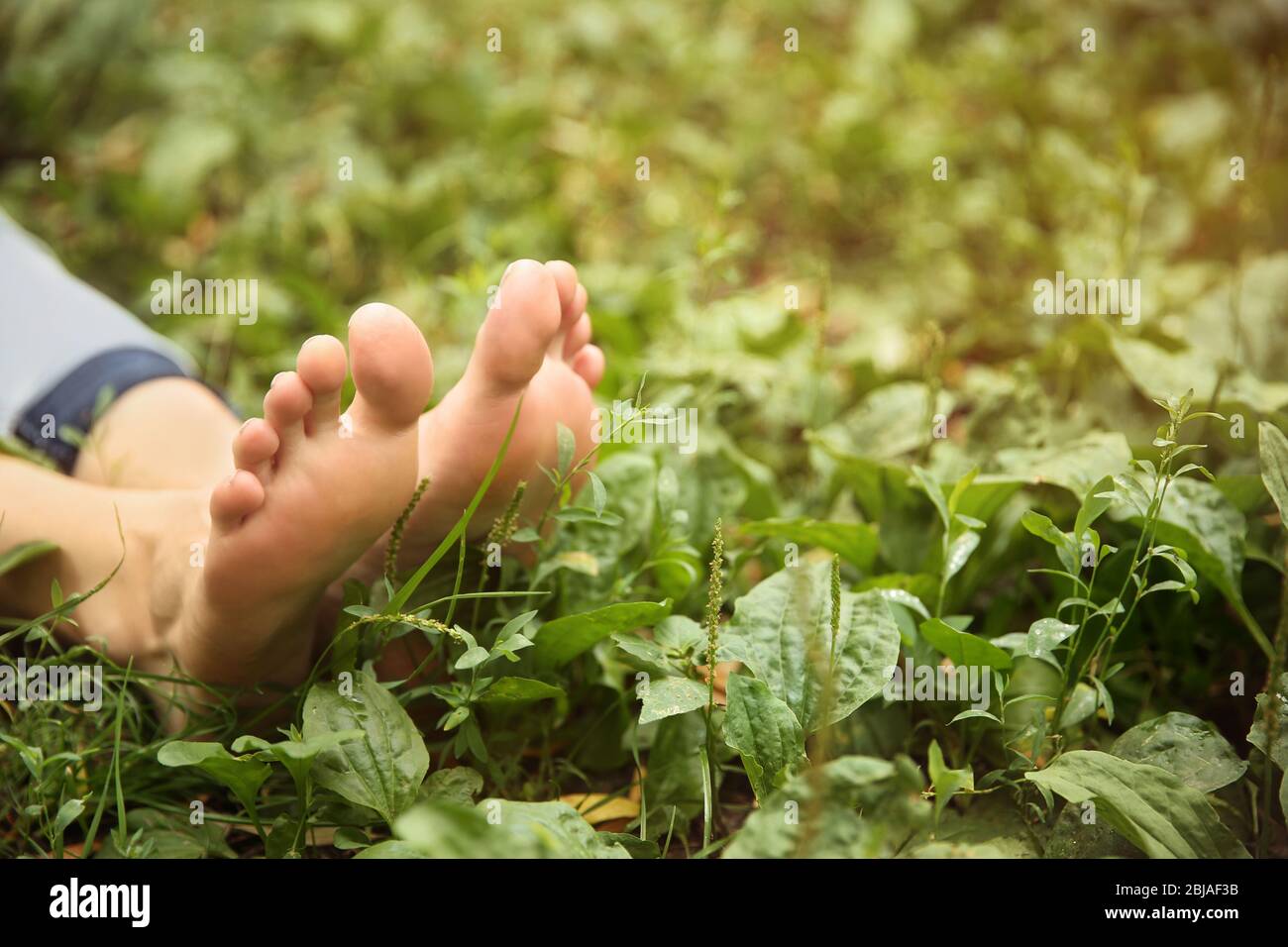 Piedi donna su sfondo erba Foto Stock
