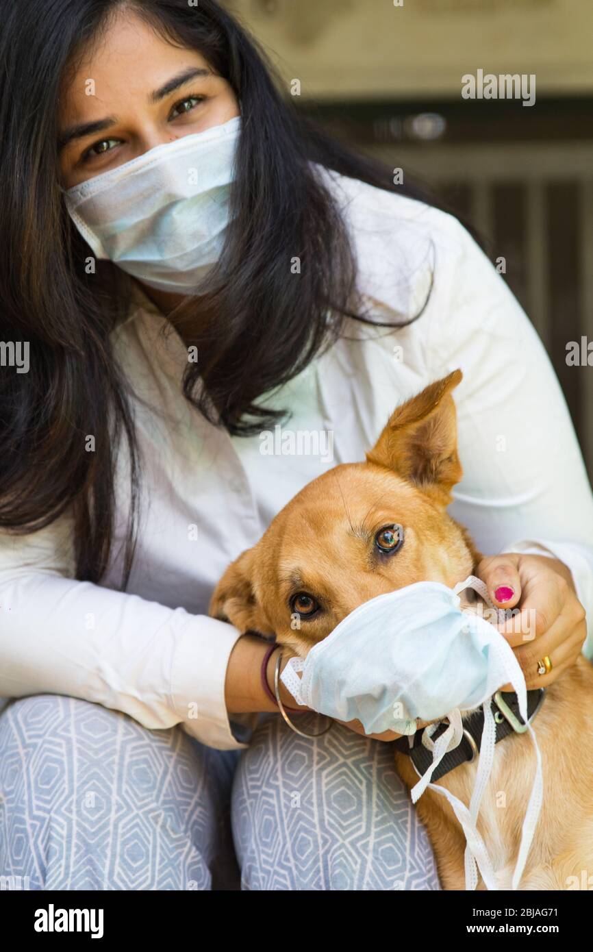 un operatore sanitario indiano e il suo cane da compagnia indossando una maschera durante la pandemia del virus corona diffondere la consapevolezza Foto Stock