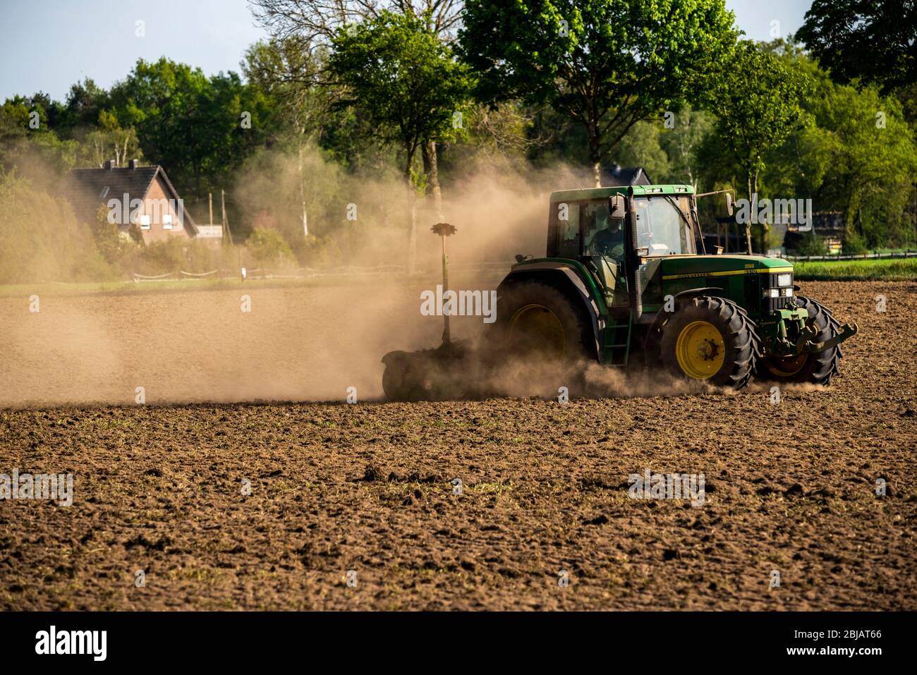 Coltivatore che lavora i campi in primavera, asciutto 2020 aprile, trattore tira nube spessa di polvere, mentre coltivando, allentando il terreno, dietro di lui, Niederrhein Foto Stock