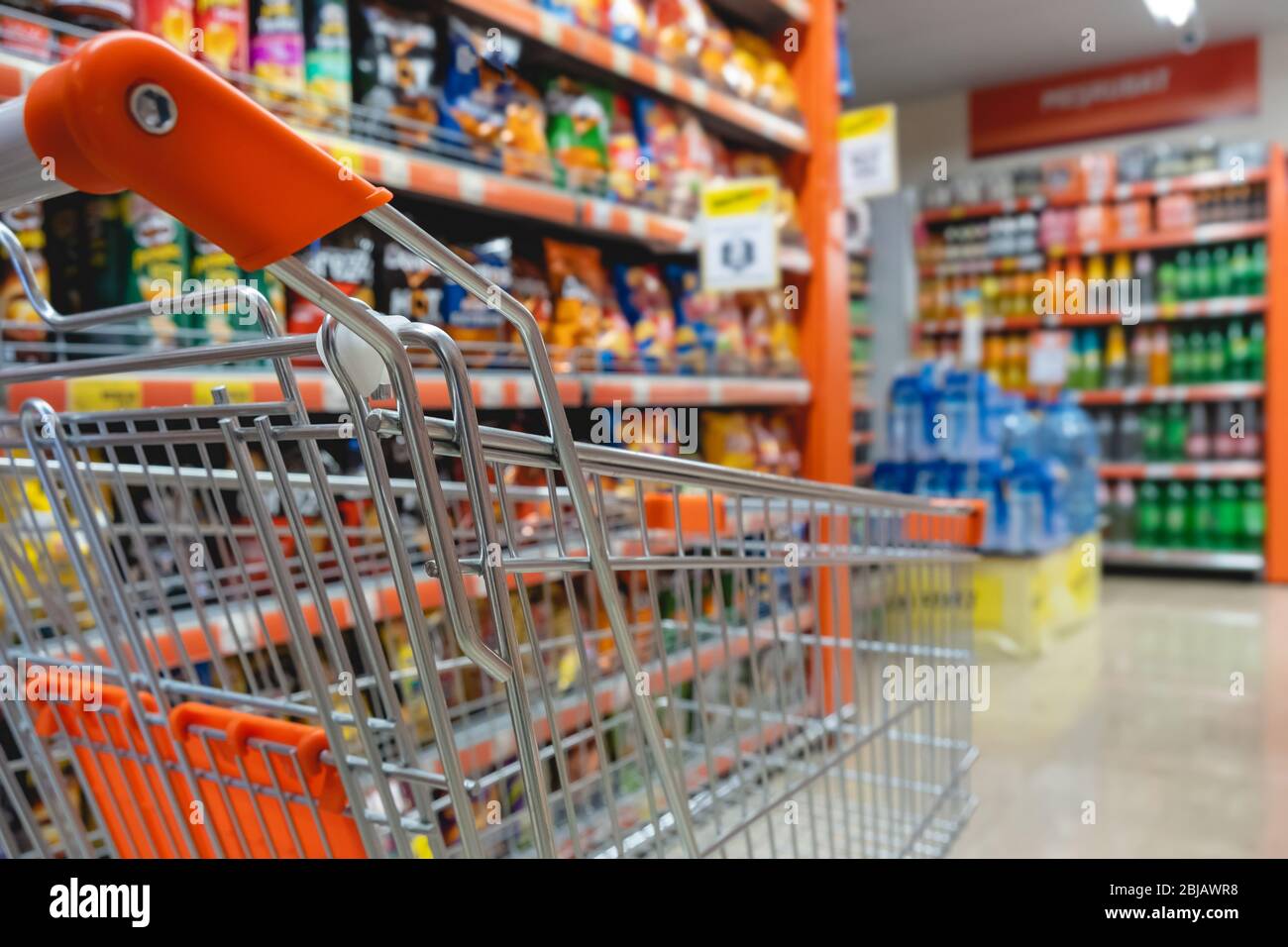 Carrello per lo shopping contro moderno supermercato corridoio sfondo sfocato Foto Stock