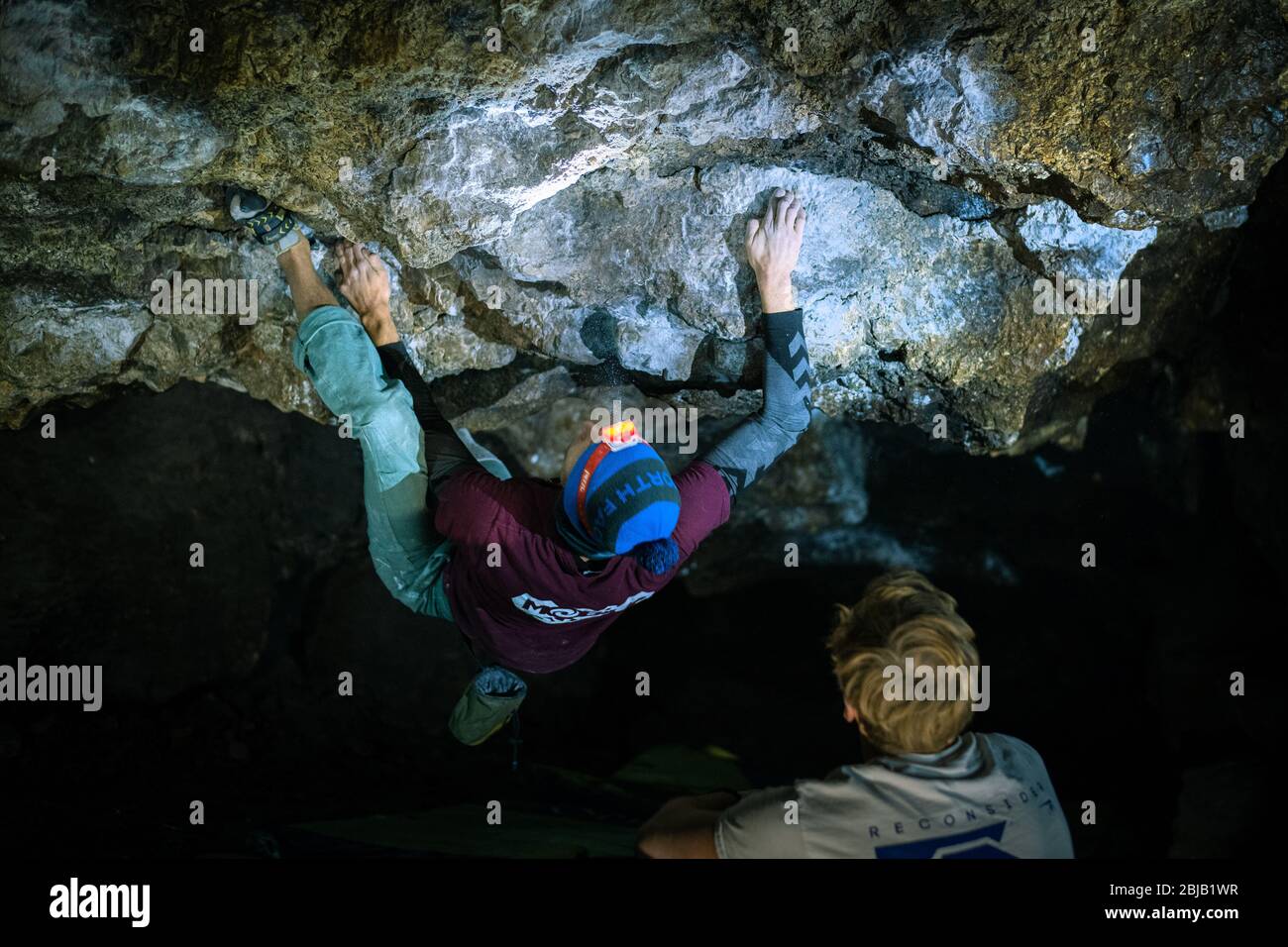 L'uomo sta facendo un masso nella grotta di Twardowski. Bouldering nella roccia. Grotta di Twardowski Foto Stock