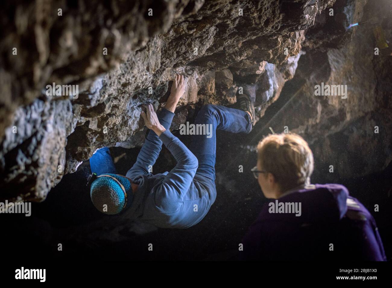 L'uomo sta facendo un masso nella grotta di Twardowski. Bouldering nella roccia. Grotta di Twardowski Foto Stock