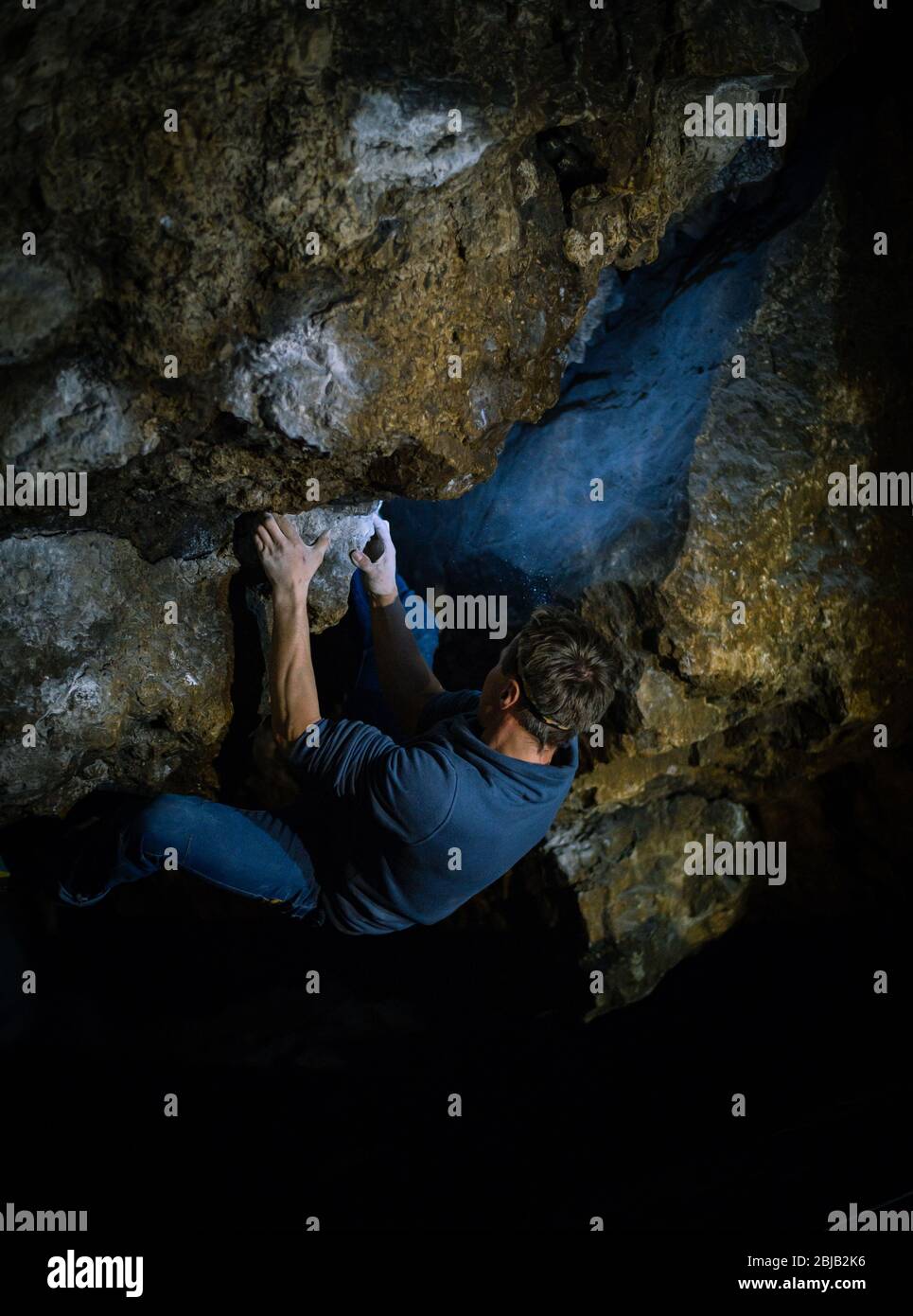 L'uomo sta facendo un masso nella grotta di Twardowski. Bouldering nella roccia. Grotta di Twardowski Foto Stock