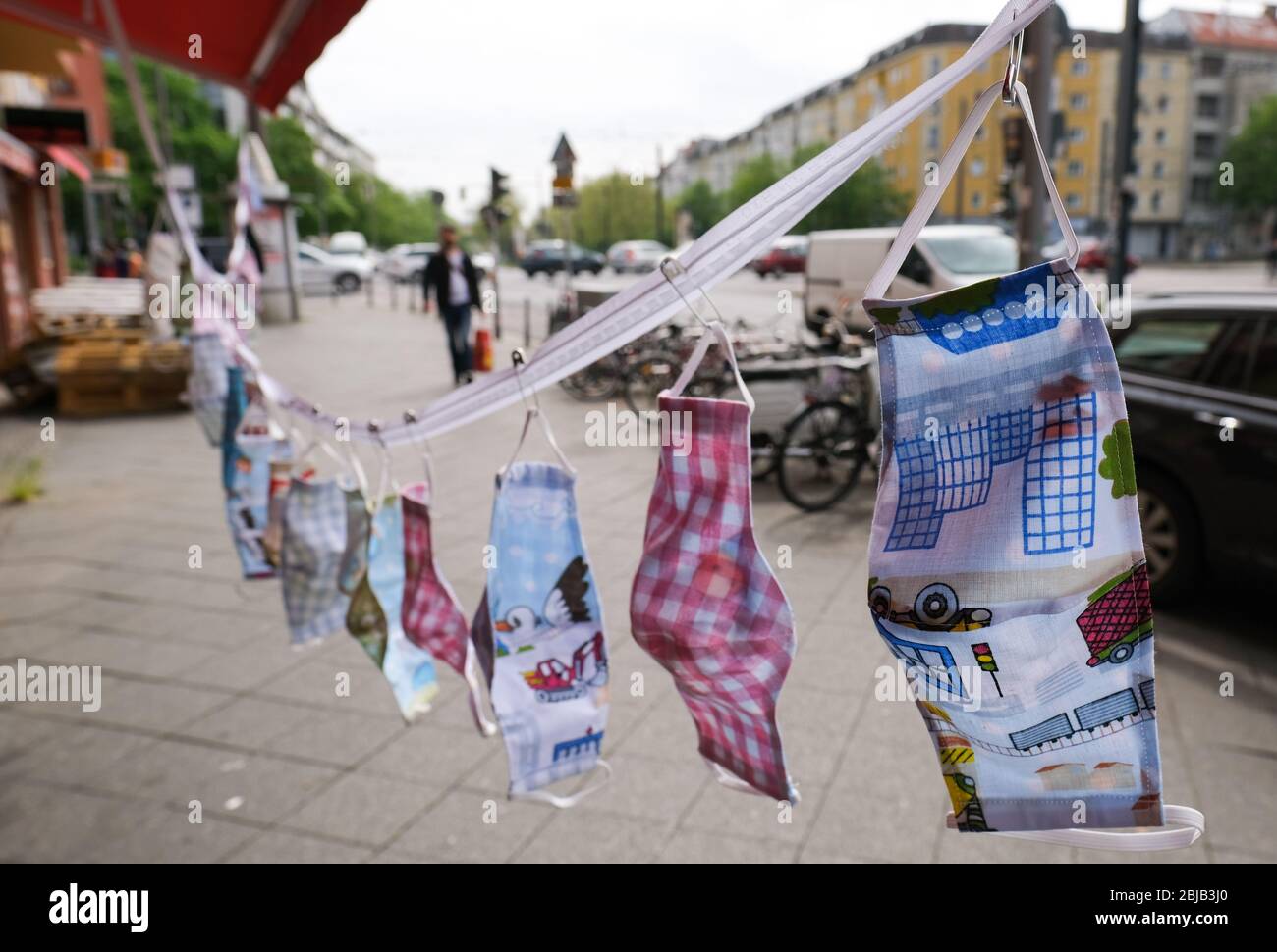 Berlino, Germania. 29 aprile 2020. Maschere autocucite come protezione per bocca e naso appendono in una grande selezione e diversi modelli di fronte a un negozio di sartoria a Danziger Straße in Prenzlauer Berg. In Germania, le maschere sono obbligatorie nei trasporti pubblici e nei negozi. Credit: Jens Kalaene/dpa-Zentralbild/dpa/Alamy Live News Foto Stock