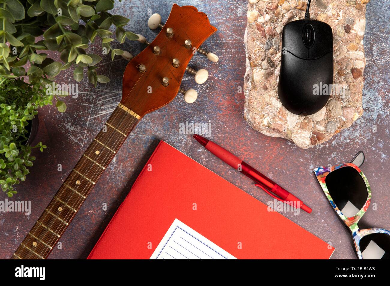 Scrivania da ufficio per scrittori musicali con uno strumento, notebook, occhiali da sole e computer. Concetto di vista dall'alto Foto Stock