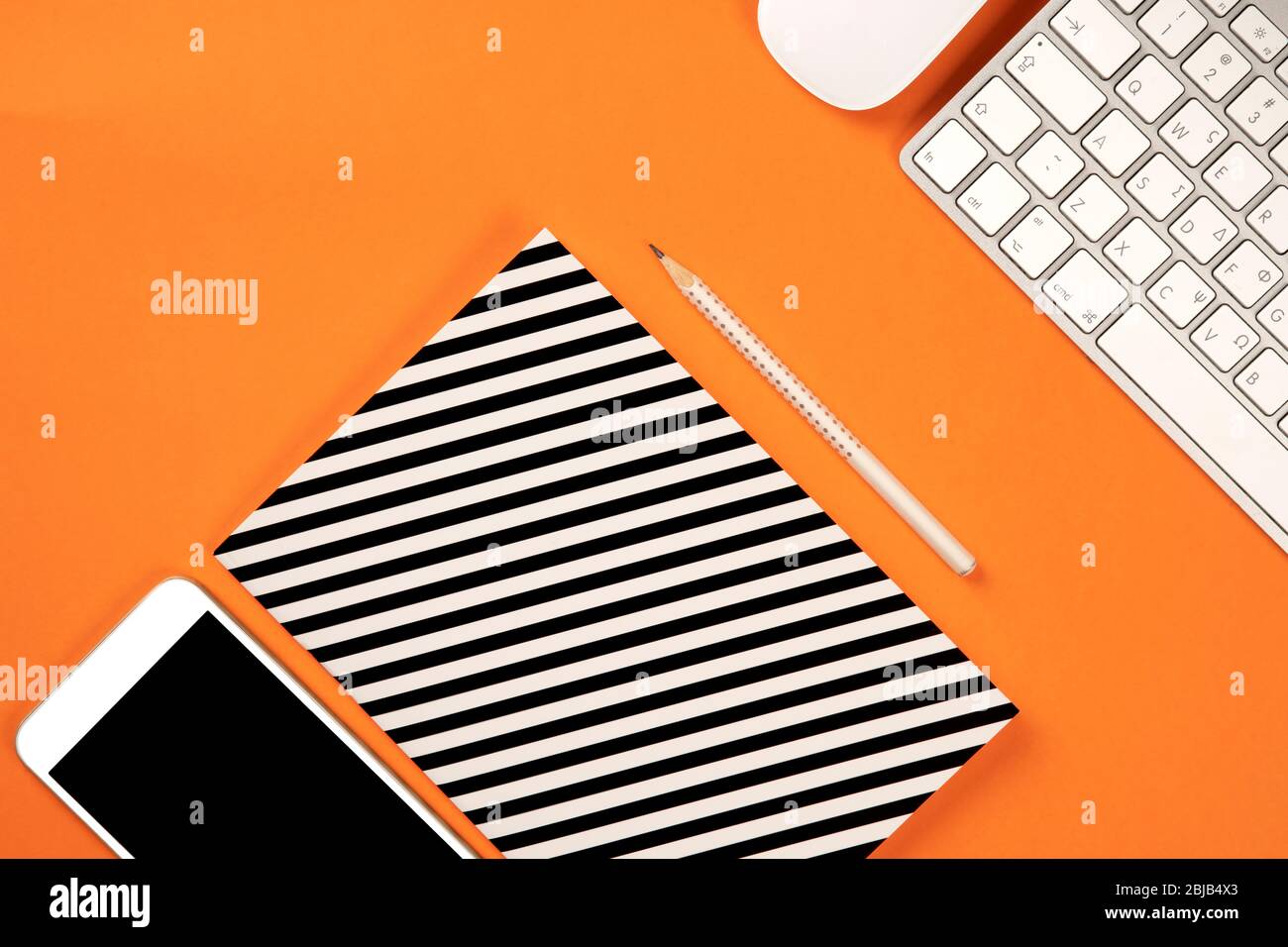 Piano, vista dall'alto, moderna scrivania da ufficio. Spazio di lavoro con notebook, computer, matita e dispositivi mobili per lavori in ufficio Foto Stock