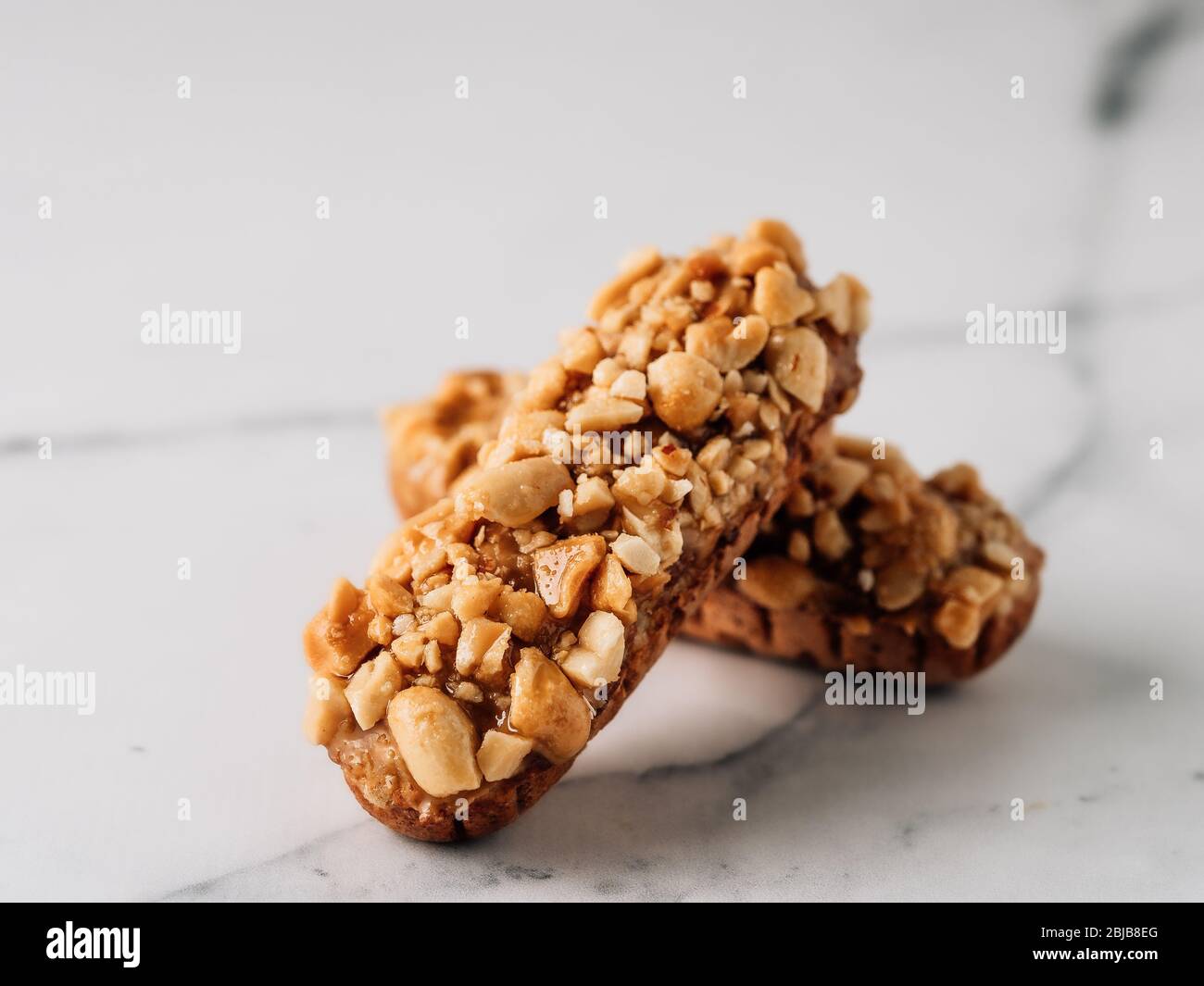 In casa eclairs con peanut su sfondo marmo. Vista ravvicinata della deliziosa profitroles sano con i dadi. Copia spazio per il testo o il design. Foto Stock