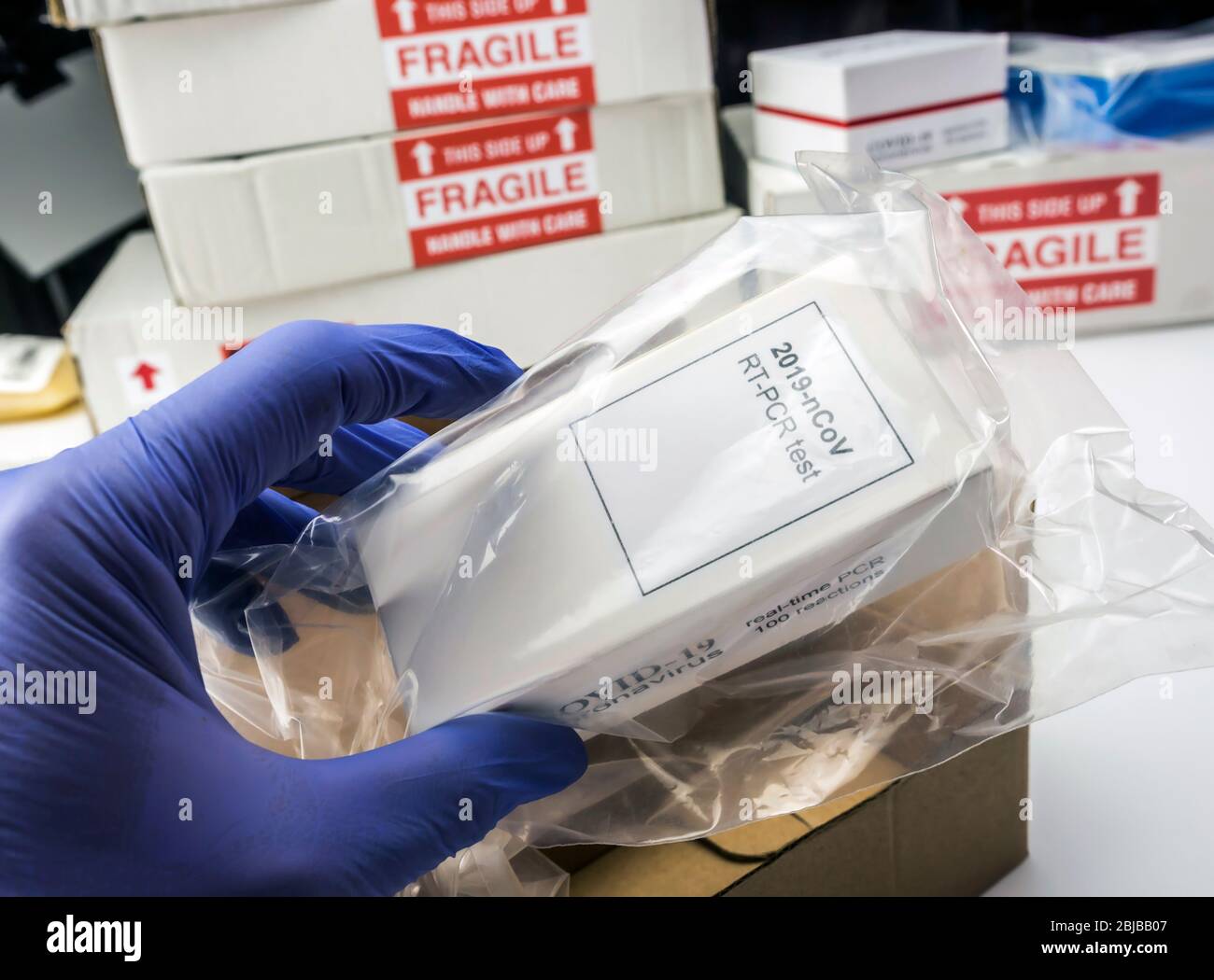 Scatola di disimballaggio infermiere con kit PCR Covid-19 in magazzino ospedaliero, immagine concettuale Foto Stock