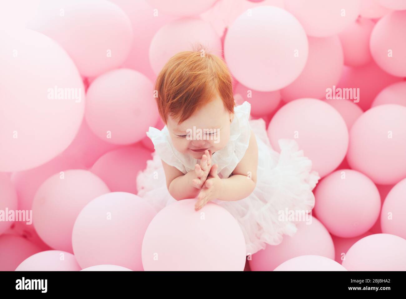 bella, 11 mesi bambina in piedi tra palloncini rosa pastello Foto stock -  Alamy