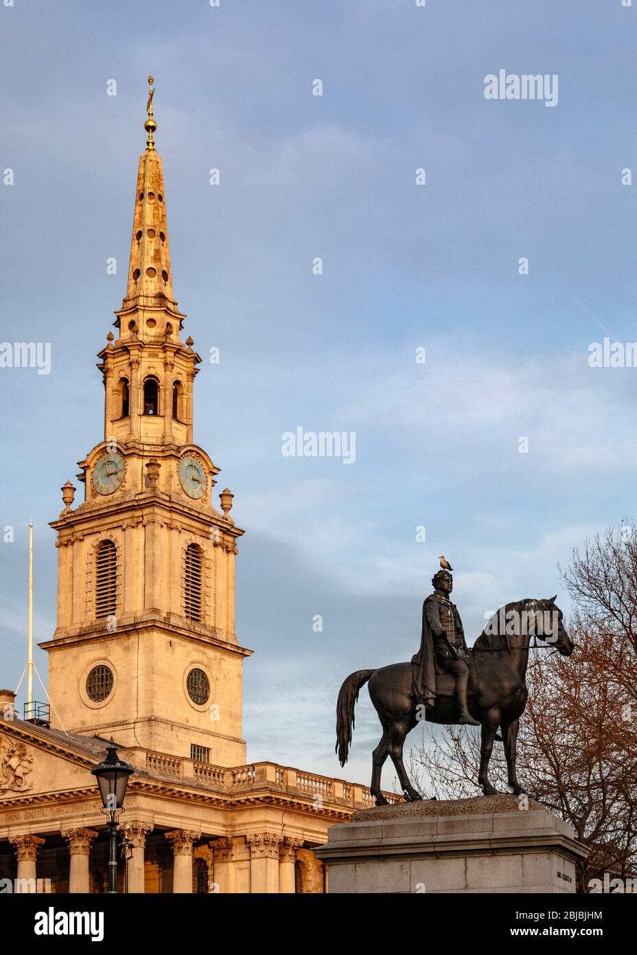 La statua equestre di Giorgio IV a Trafalgar Square con il campanile di San Martino in campi sullo sfondo Foto Stock