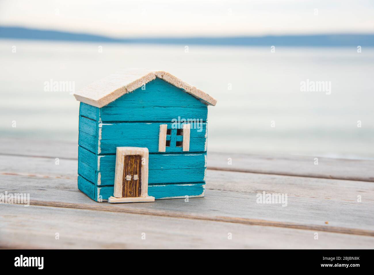 modello di casa in legno sulla spiaggia. soggiorno a casa stare al sicuro Foto Stock