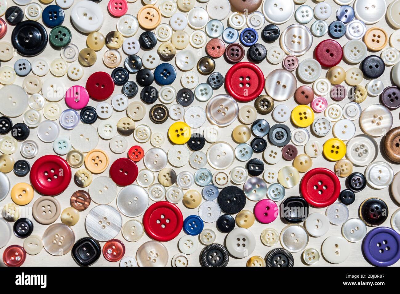 Collezione di bottoni di abbigliamento di varie dimensioni e colori Foto Stock