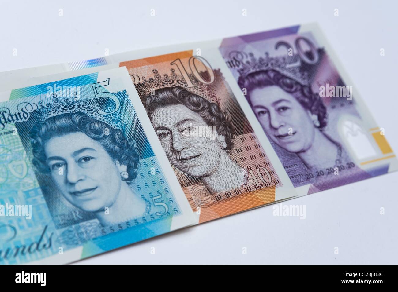 Banconote in sterline britanniche poste l'una sull'altra. La foto include una nuova banconota da 20 libbre rilasciata nel febbraio 2020. Primo piano. Foto Stock