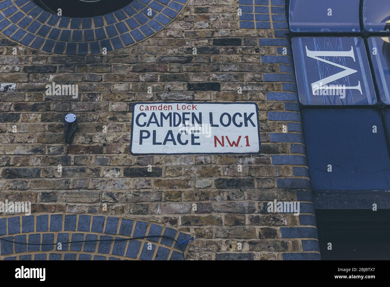 Cartello con il nome Camden Lock Place dipinto sulle pareti dell'edificio sul Camden Market di Londra. Un cartello con il nome della strada è un tipo di cartello utilizzato per identificare il nome Foto Stock