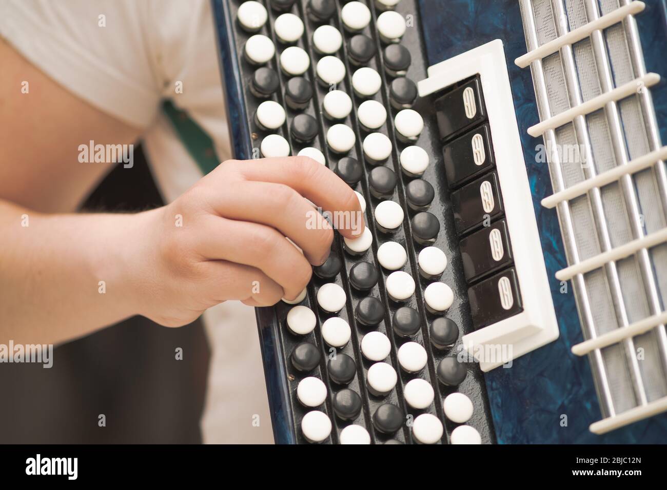 Fisarmonica nelle mani di un musicista, vista ravvicinata. Immagine di musica di strada, busker che suona un melodeon Foto Stock