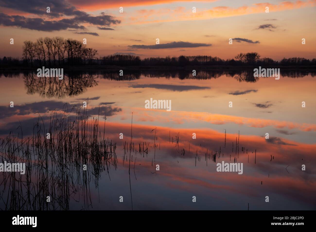 Nuvole di bellezza dopo il tramonto che si riflettono sulla superficie del lago Foto Stock