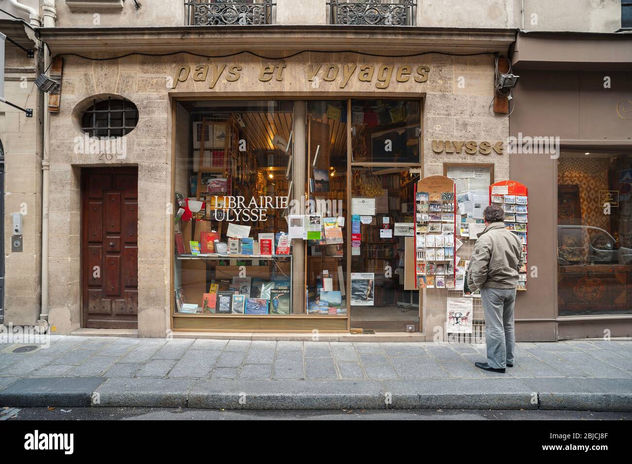 Negozio di libri di Parigi, vista di un uomo che guarda la parte anteriore della libreria Librairie Ulysse in Rue Saint-Louis nel centro di Parigi, Francia. Foto Stock