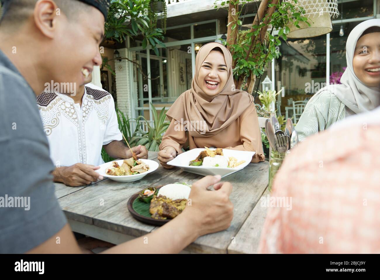 i musulmani rompono il digiuno insieme. amici e famiglia seduti insieme gustare la cena iftar Foto Stock