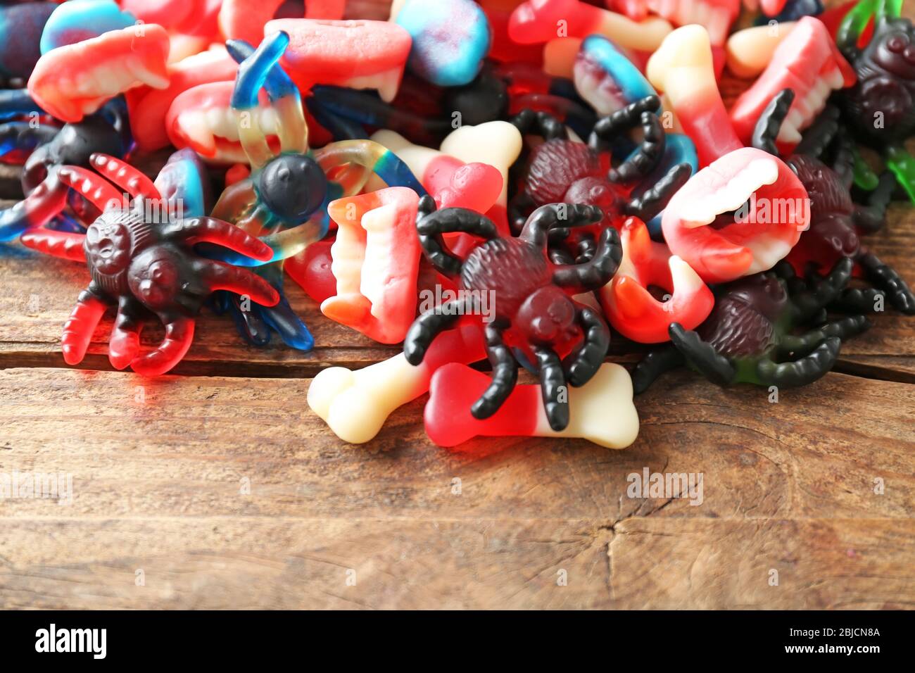 Mucchio di caramelle assortite di gelatina su sfondo di legno Foto Stock