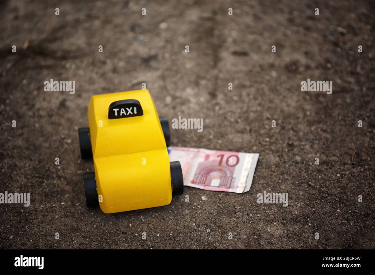 Taxi giocattolo giallo con soldi a terra Foto Stock