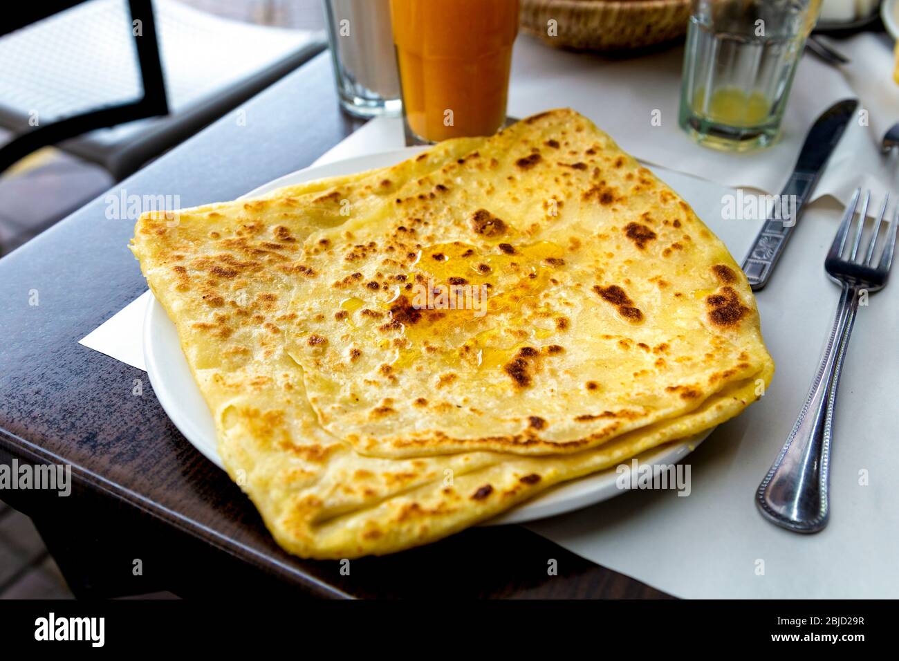 Frittelle semen / pane piatto con miele a Marrakech, Marocco Foto Stock