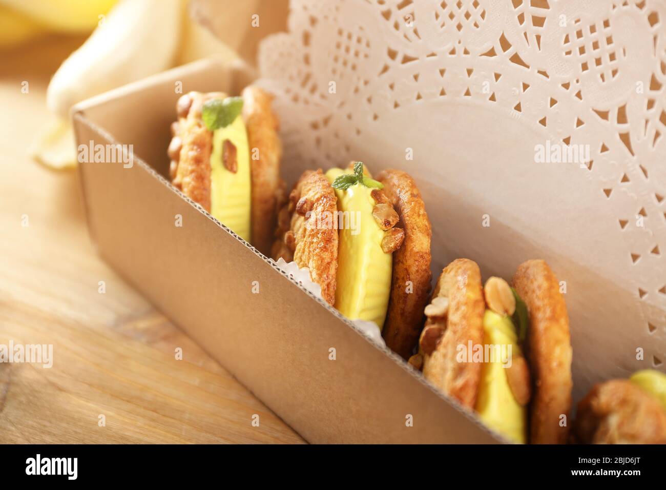 Cartone animato con deliziosi panini gelato al limone su tavolo di legno, primo piano Foto Stock