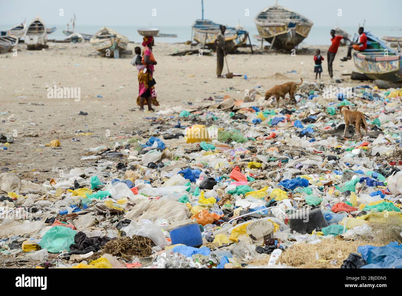 SENEGAL, Joal, pescatore di costa, barche di legno sulla riva dell'oceano atlantico, cane da strada in rifiuti di plastica, cani randagi / Küstenfischer und Holzboote am Atlantik Foto Stock