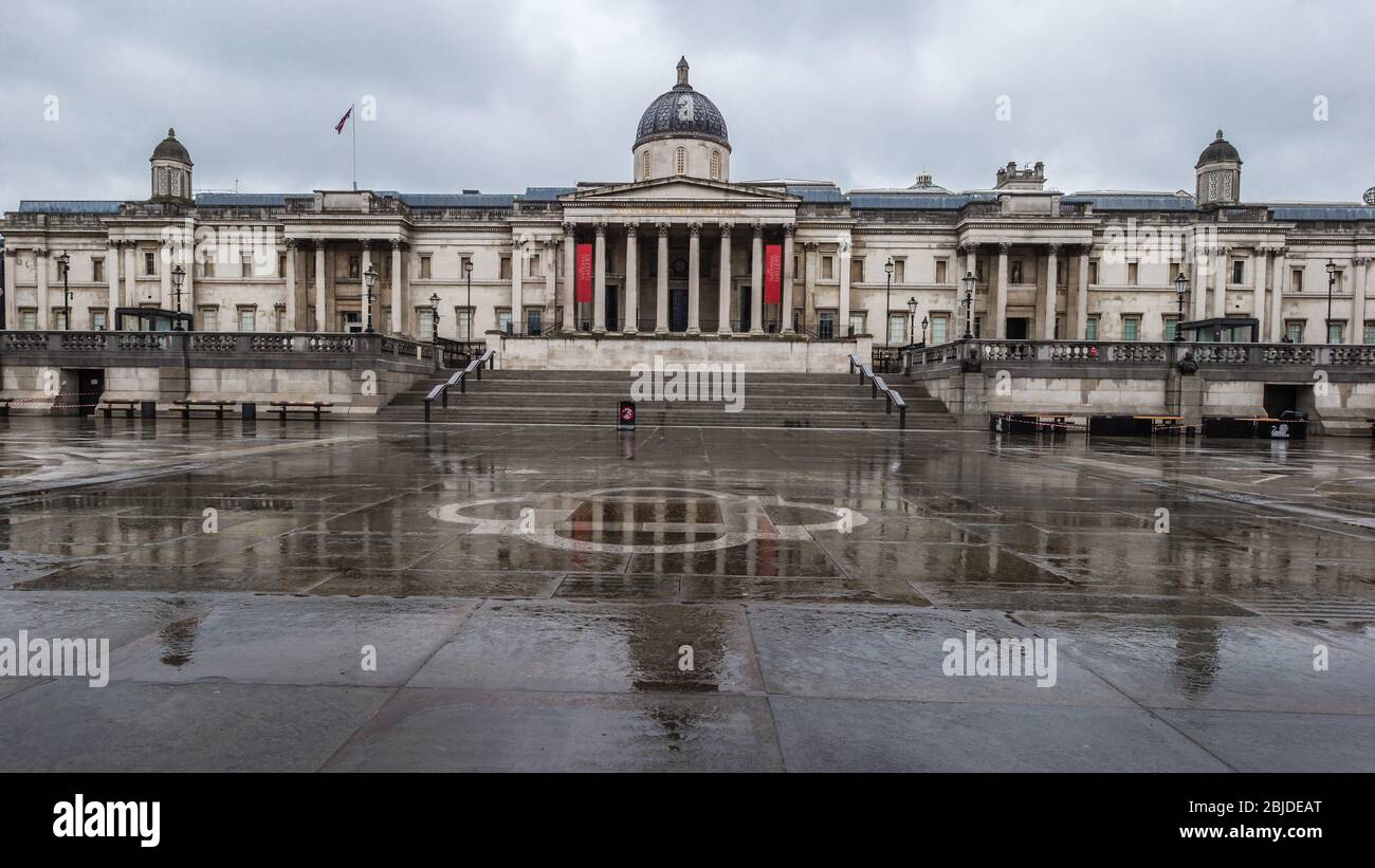 Una città fantasma bagnata di Trafalgar Square in una Londra deserta durante la crisi sanitaria pandemica del coronavirus nel 2020 Foto Stock
