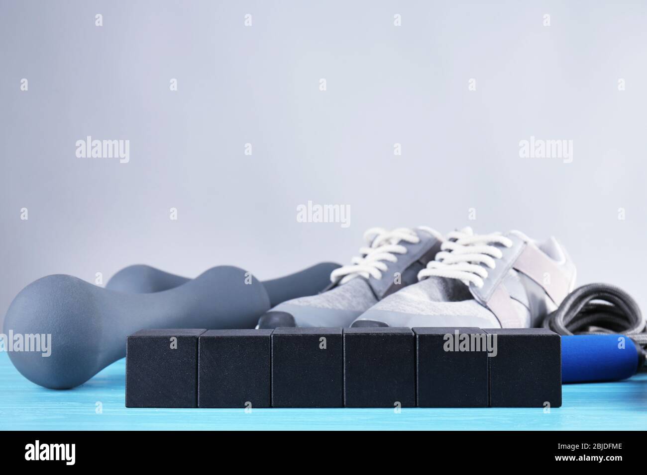 Cubi con spazio per testo, scarpe da jogging e campane su sfondo grigio Foto Stock