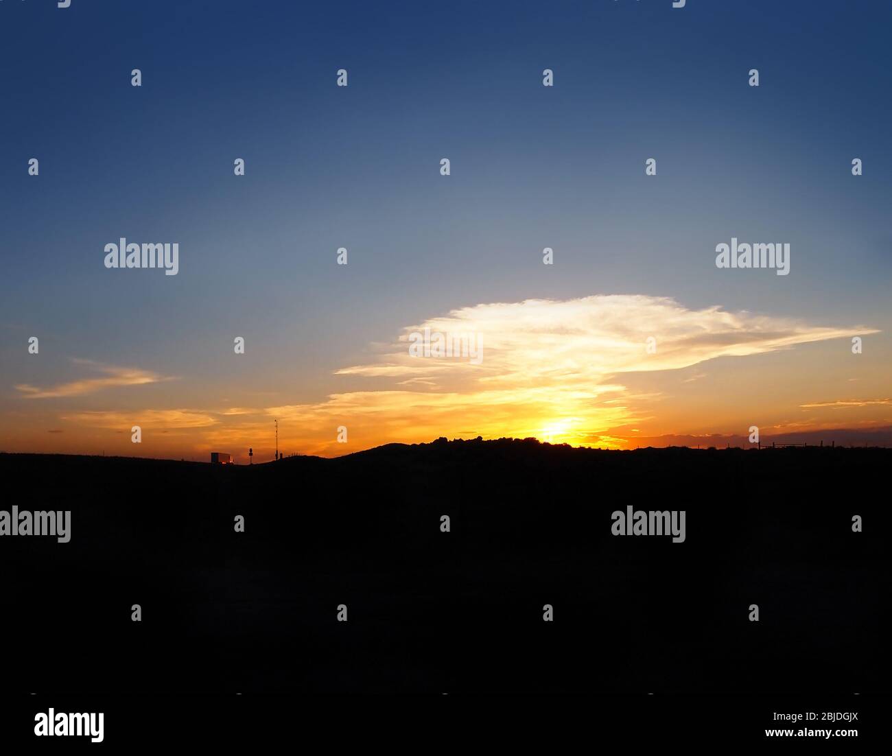 Un semirimorchio su strada in lontananza si muove verso il tramonto. Foto Stock