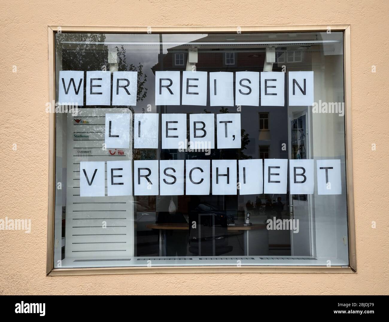Monaco, Baviera, Germania. 29 aprile 2020. Una rima nella finestra di un agente di viaggio a Monaco, in Germania, che legge ''chi ama il viaggio lo ritarda''. Le aziende in Baviera, Germania, stanno riaprendo come parte delle misure di rilassamento che limitano tutti i negozi a 800 metri cubi e richiedono l'applicazione dell'igiene nei negozi, come limitare i clienti e consentire solo ai clienti mascherati in. Credit: Sachelle Babbar/ZUMA Wire/Alamy Live News Foto Stock
