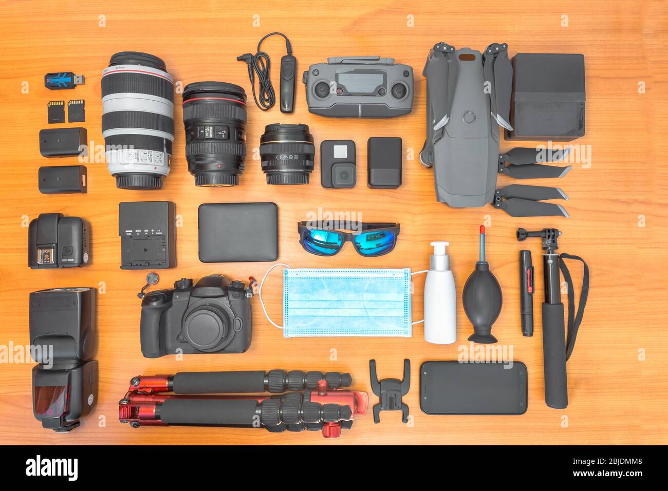 2020 fotografo freelance luogo di lavoro in tempi di COVID-19 con maschera, igienizzante, occhiali di protezione su tessuto di legno con attrezzatura fotografica, fotocamera, len Foto Stock