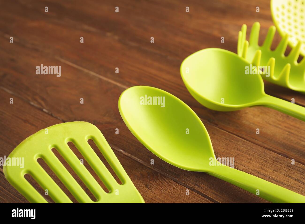 Set di utensili da cucina diversi su tavolo in legno Foto Stock