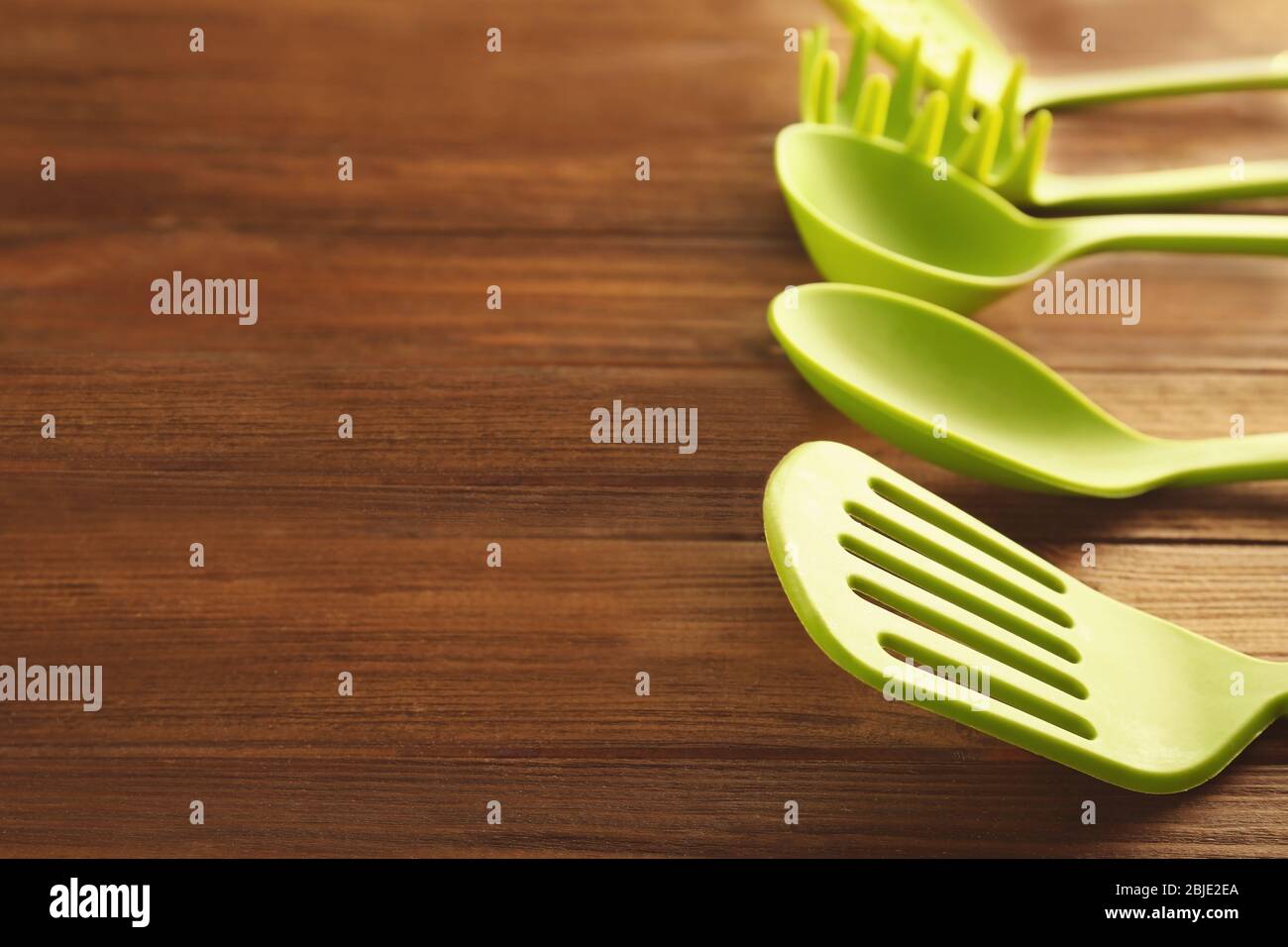 Set di utensili da cucina diversi su tavolo in legno Foto Stock