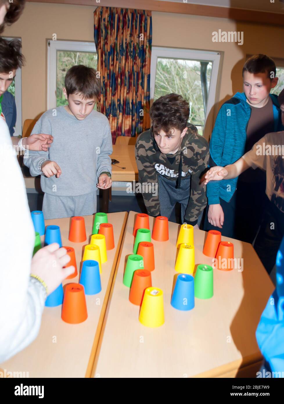I bambini e gli adolescenti giocano un gioco intellettuale con coppe monouso multicolore numerate, team building Foto Stock