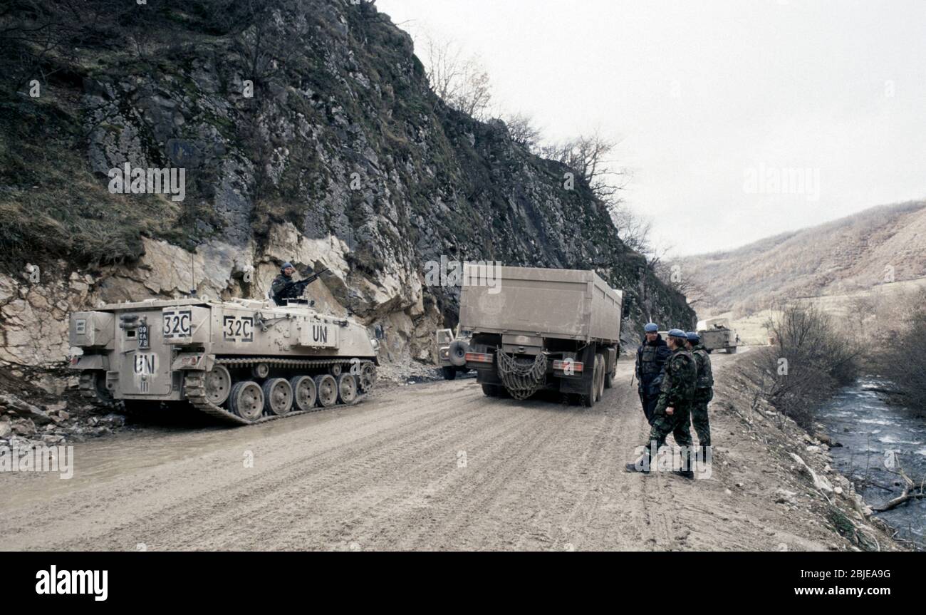5 febbraio 1994 durante la guerra nella Bosnia centrale: Accanto al fiume Bistrica, un convoglio congiunto a sud dell'esercito belga e dei camion norvegesi UHCR passa attraverso un checkpoint dell'esercito britannico/musulmano bosniaco sulla Route Diamond, appena a nord di Gornji Vakuf. Foto Stock