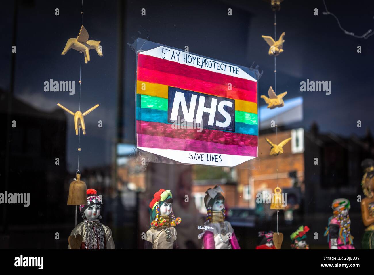 Un incoronavirus arcobaleno 'Stay Home and Protect our NHS -Save Lives' messaggio segno nella finestra di un ristorante chiuso a Southampton 2020, Inghilterra, Regno Unito Foto Stock