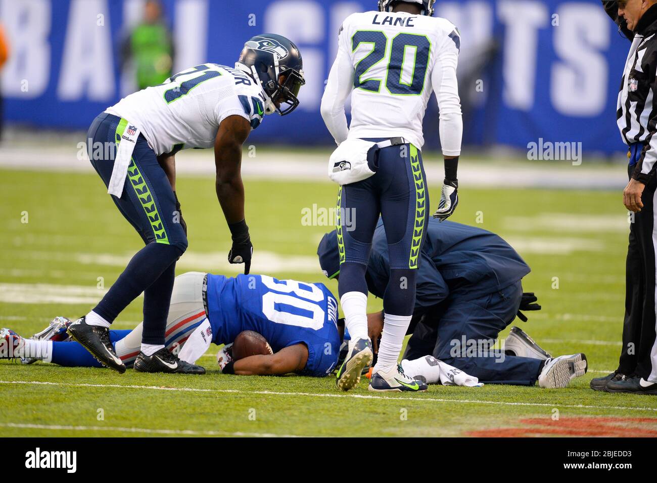 15 dicembre 2013: Seattle Seahawks formazione staff esce sul campo per guardare il New York Giants ampio ricevitore Victor Cruz (80) dopo aver colpito il tappeto erboso Foto Stock